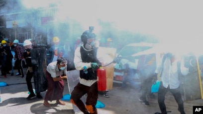 在缅甸仰光，反对军队政变的抗议者用消防器应对警方对示威者释放催泪瓦斯后造成的效果。(2021年3月4日)